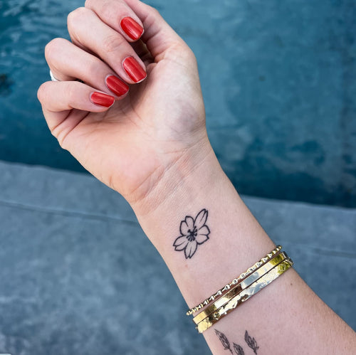 Tatouage petite fleur poignet femme